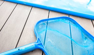 Yaz mevsiminde havuzun kenarındaki el ağı temizleme işlemi