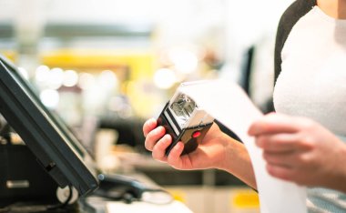 Concept of small business or sevice, woman or saleswoman in an apron at counter with cashbox working at clothes shop, touchscreen POS, finance concept, business