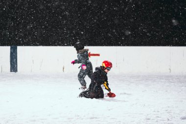 24.11.2021. Moskova 'da şiddetli kar yağışı var. Çocuklu insanlar Tsaritsyno parkı yakınlarındaki buz pateni pistinde