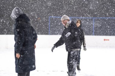 24.11.2021. Moskova 'da şiddetli kar yağışı var. Çocuklu insanlar Tsaritsyno parkı yakınlarındaki buz pateni pistinde