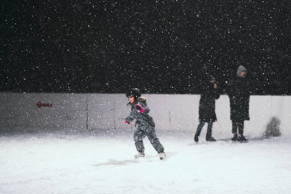 24.11.2021. Moskova 'da şiddetli kar yağışı var. Çocuklu insanlar Tsaritsyno parkı yakınlarındaki buz pateni pistinde