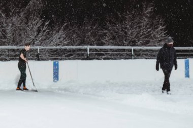 03.12.2021. Moskova 'da şiddetli kar yağışı var. Çocuklu insanlar Tsaritsyno parkı yakınlarındaki buz pateni pistinde