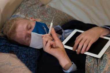 Covid-19. Adamın bir hastalığı var ve iş kıyafetleriyle evde çalışıyor.