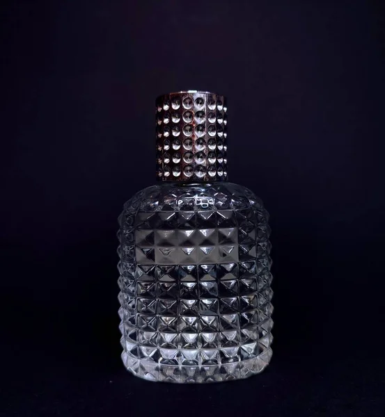 cosmetic bottle with spray on black background