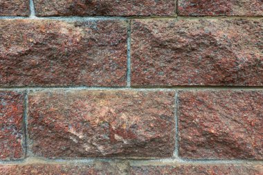 Kırmızı beton kiremitlerden yapılmış bir duvar parçası. Yüzeyde çeşitli kabartmalar var. Geçmişi. Doku. 