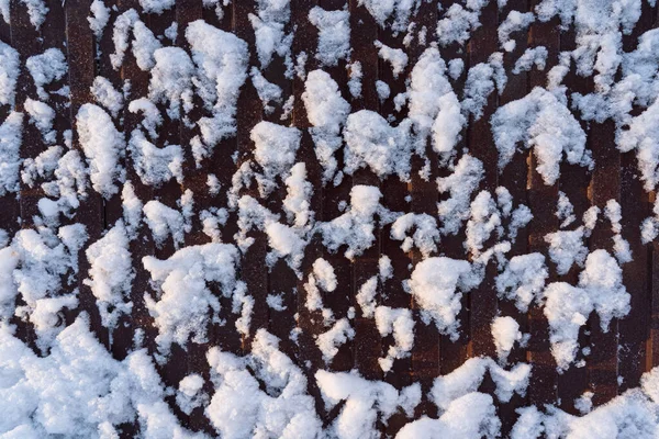 金属製のフェンスのシートの上に凍結雪は森の中のモミの木の上のように見えます 表面には太陽からの霜やグレアがあります テクスチャ — ストック写真