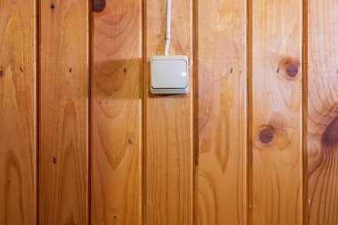 White electrical switch on a yellow wooden wall. Background. Texture. 