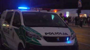 Polis arabasının tepesinde mavi ışık yanıp sönüyor..