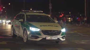 Polis arabasının tepesinde mavi ışık yanıp sönüyor..