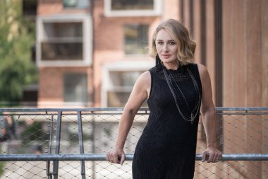 Beyaz, beyaz, beyaz, yetişkin bir kadının portresi boynunda siyah elbise ve bijouterie var. Arka plandaki Vilnius Eski Kasabası. Litvanya.