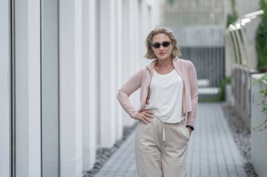 Güzel Beyaz Kafkas Yetişkin Kadın 'ın portresi Aktif Yaşam Tarzı Açık Hava Spor Giyimi Giyiyor. Koyu güneş gözlüğü. Vilnius, Litvanya. Beyaz tişört.