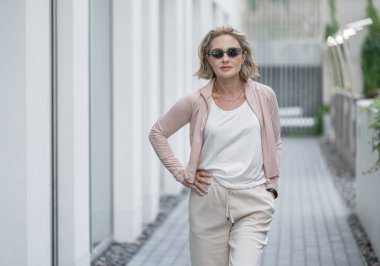 Güzel Beyaz Kafkas Yetişkin Kadın 'ın portresi Aktif Yaşam Tarzı Açık Hava Spor Giyimi Giyiyor. Koyu güneş gözlüğü. Vilnius, Litvanya. Beyaz tişört.