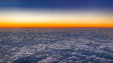 Kalın bir bulut tabakasının üzerinde uçan uçaktan akşam gökyüzüne bakın. Hava yolculuğu ve ulaşım kavramı.