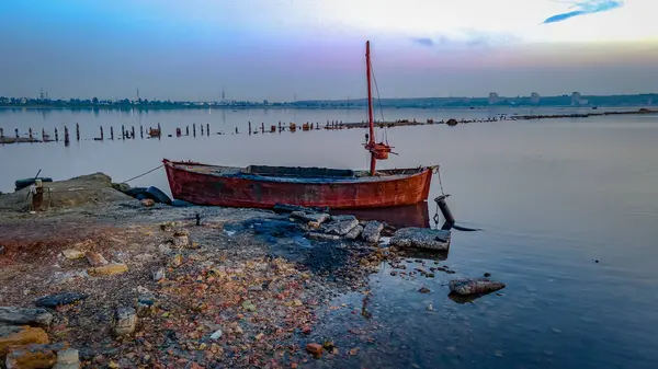 An abandoned fishing boat lies on a rocky estuary beach, Odessa, Ukraine — Stock Photo, Image