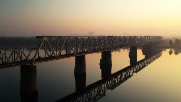 ウクライナのドニエプル川に架かる鉄道橋の4Kビデオ キエフ市 ドローンからの映像だ 橋に沿って飛行します 夜明けだ 空の道だ 高品質4K映像 — ストック動画