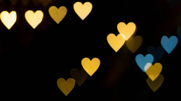 黒の背景に黄色のハートボケ 愛の概念 バレンタインデーのテーマ 高品質の写真 — ストック写真