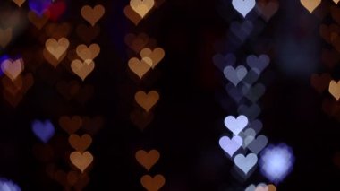 Sevgililer Günü için 4K UHD video geçmişi. Siyah arka planda parlayan ve parıldayan kalplerle dolu bir sınır. Aşk, kalp şeklinde bokeh. Yüksek kalite 4k video.