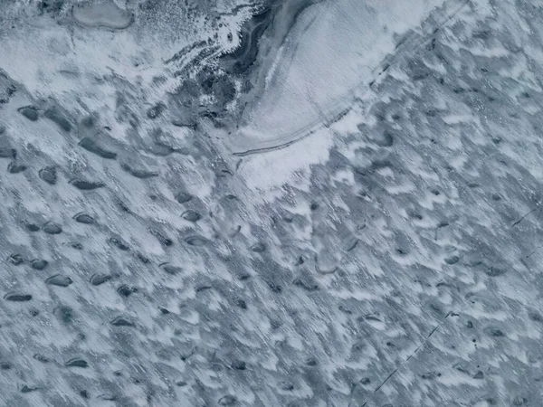 Donmuş göl yüzeyinin soyut sanatsal dokusunun üst görüntüsü. Kaliteli fotoğraf