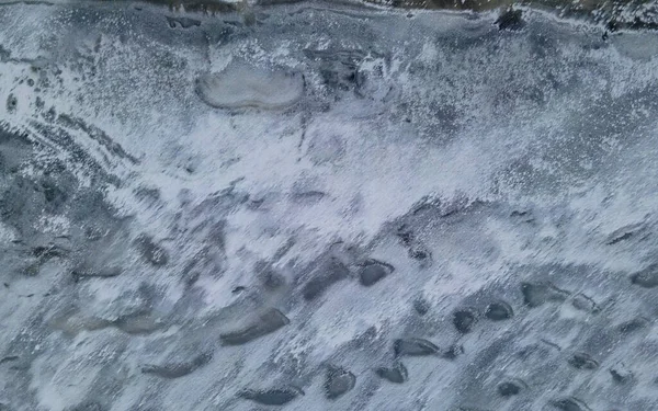 Donmuş göl yüzeyinin soyut sanatsal dokusunun üst görüntüsü. Kaliteli fotoğraf