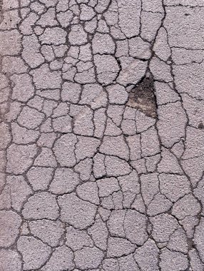 Eski yol arkaplanı - gri çatlamış asfalt yüzeyi yakın çekim. Yol yüzeyinin aşınma ve yırtılma konsepti. Yüksek kalite fotoğraf