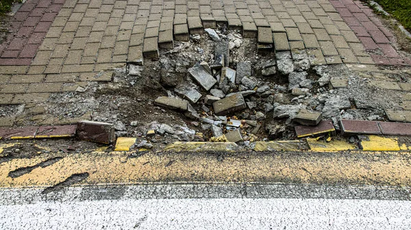 BUCHA, UKRAINE - June 20, 2022: crater funnel from a snard explosion at a crosswalk, sidewalk, asphalt. High quality photo