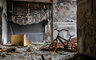 Irpin, Ukrayna - 22 Mayıs 2022: Rus birlikleri tarafından işgal edildikten sonra yıkılan bir evde yanmış bir çocuk bisikleti. Yüksek kalite fotoğraf.