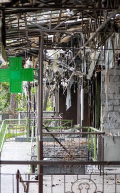 Irpin, Ukrayna - 22 Mayıs 2022: Rus füzelerinin bir yerleşim bölgesine yaptığı hava saldırısından sonra yanmış bir binanın ön cephesinde bir eczanenin işareti hayatta kaldı. Yüksek kalite fotoğraf.