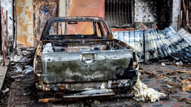 Irpin, Ukrayna - 22 Mayıs 2022: Bombalanan bahçede bir araba yandı. Barışçıl bir şehrin Rus birlikleri tarafından işgal edilmesinin sonuçları. Yüksek kalite fotoğraf