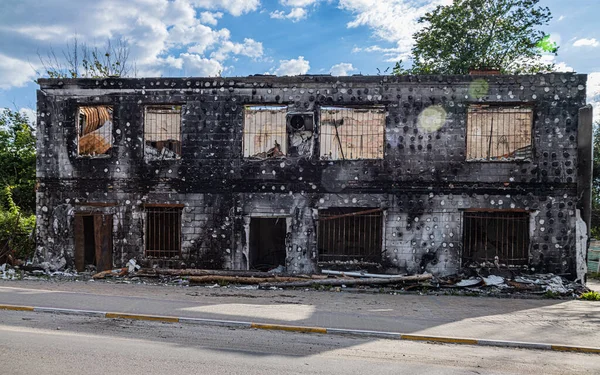 Irpin, Ukrayna - 22 Mayıs 2022: Rus mermisinin etkisiyle evin ön cephesi yıkıldı. Irkçılık. Ukrayna 'da savaş. Sivil binaların yıkımı. Yüksek kalite fotoğraf.