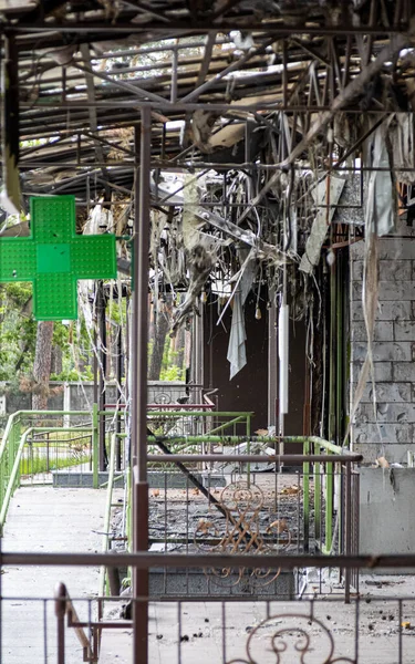 Irpin, Ukrayna - 22 Mayıs 2022: Rus füzelerinin bir yerleşim bölgesine yaptığı hava saldırısından sonra yanmış bir binanın ön cephesinde bir eczanenin işareti hayatta kaldı. Yüksek kalite fotoğraf.