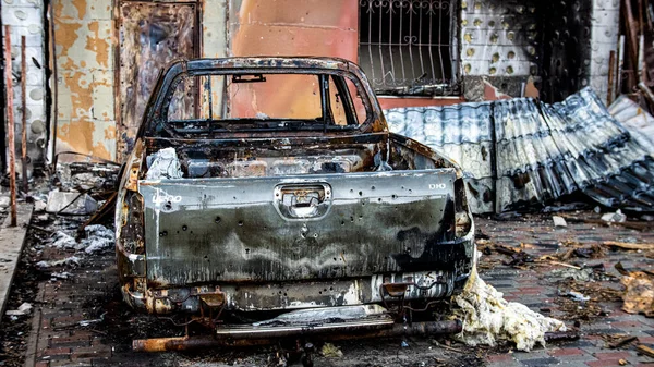 Irpin, Ukrayna - 22 Mayıs 2022: Bombalanan bahçede bir araba yandı. Barışçıl bir şehrin Rus birlikleri tarafından işgal edilmesinin sonuçları. Yüksek kalite fotoğraf