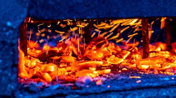 Burning coals in a barbeque, background, coals glowing in the background, view from the middle. High quality photo.