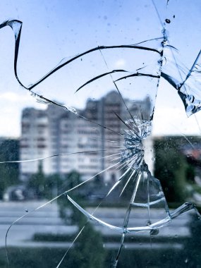 A close-up view through the broken glass of the surviving house opposite. The concept of the destruction of peaceful buildings during war. High quality photo.