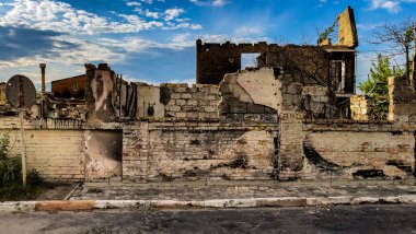 Irpin, Ukraine - May 22, 2022: destroyed facade of the house due to the impact of a Russian projectile. Racism. War in Ukraine. Destruction of civilian buildings. High quality photo.