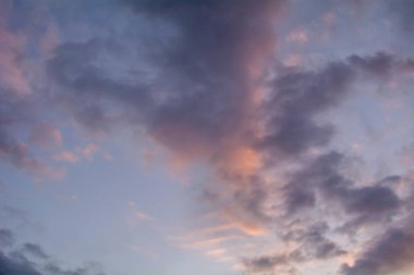 Gökyüzündeki bulutlar batan güneşle aydınlanıyor..