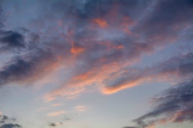 Gökyüzündeki bulutlar batan güneşle aydınlanıyor..