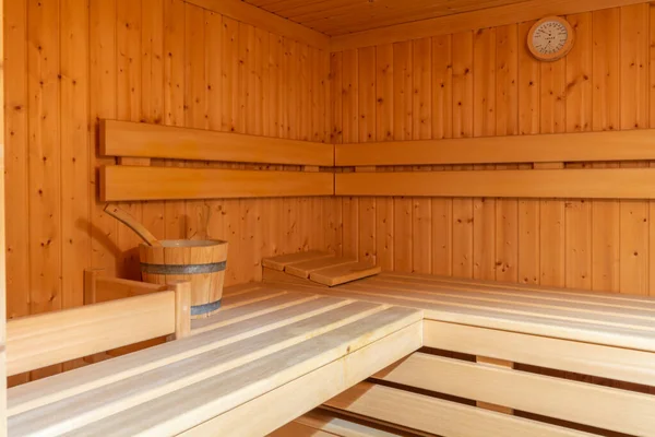 A small home sauna, lined with wood.