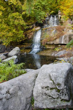 Suyla dolu bir nehirde şelale, sonbahar doğası.