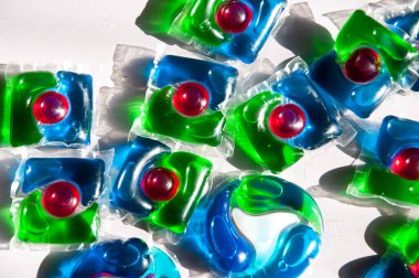 Çamaşır deterjanları. Çamaşır kapsülü arka planında yumuşatıcı.