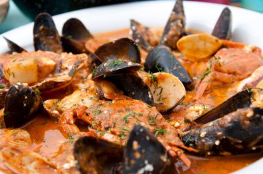 Kabuklu midye, kabuklu deniz ürünleri ve beyaz tabakta sos..