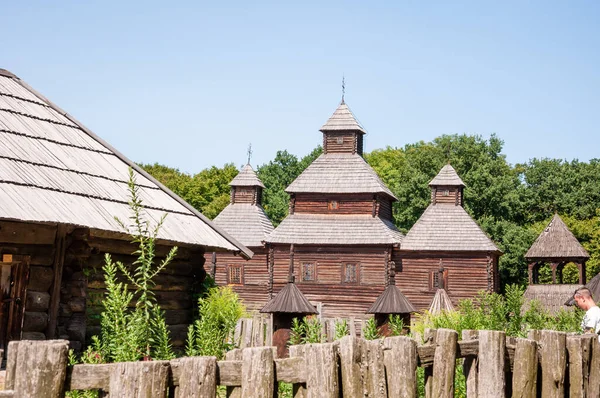 Ukrayna 'nın Pyrohiv kentindeki etnografik açık hava müzesinde eski ahşap kilise ve köy halk mimarisi.