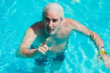 Grizli adam Malibu havuzunda işaret ediyor. Malibu 'da yaz tatili. Malibu Resort 'u işaret eden adam..