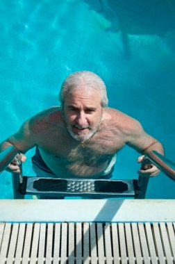 Bermuda havuzunda boz adam. Bermuda 'da yaz tatili. Adam bermuda otelinde yüzüyor..