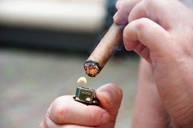 Kül ile Küba purosu. Küba purosuyla çakmak. Lüks Küba purosu içiyor, yakın plan..