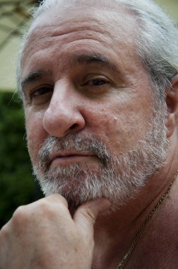 Gülümseyen, sakallı, emekli yaşlı bir adam..