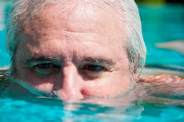 retirement summer vacation. old man in swimming pool. closeup.