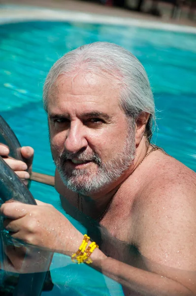 grizzled man in cuba pool. summer vacation in cuba. man swim in cuba resort.