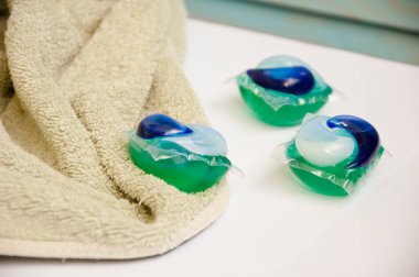 Çamaşır deterjanı. Çamaşır kapsülleri havluda. ev ve çamaşırhane.