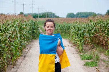 ukraine woman in field with ukrainian flag. freedom.