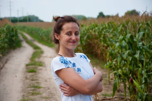 smiling ukraine woman in field with ukrainian embroidery.
